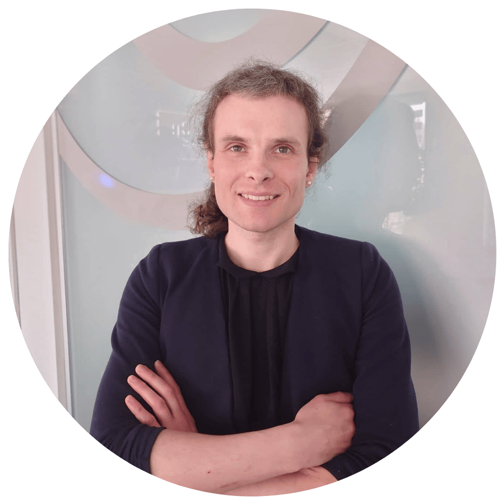 Nico Anders, Software Developer bei Kalkül IT, steht mit verschränkten Armen und lächelt freundlich vor dem Firmenlogo.